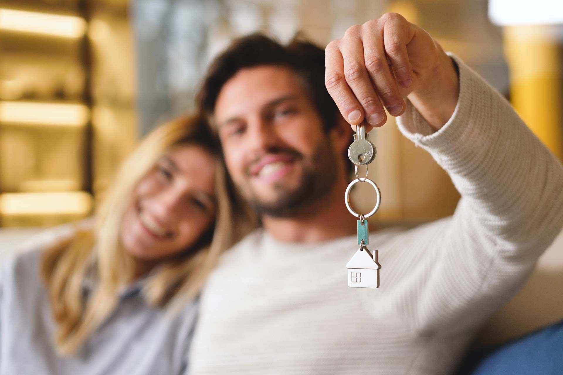 Una pareja de hombre y mujer, recibiendo las llaves de su nuevo hogar.