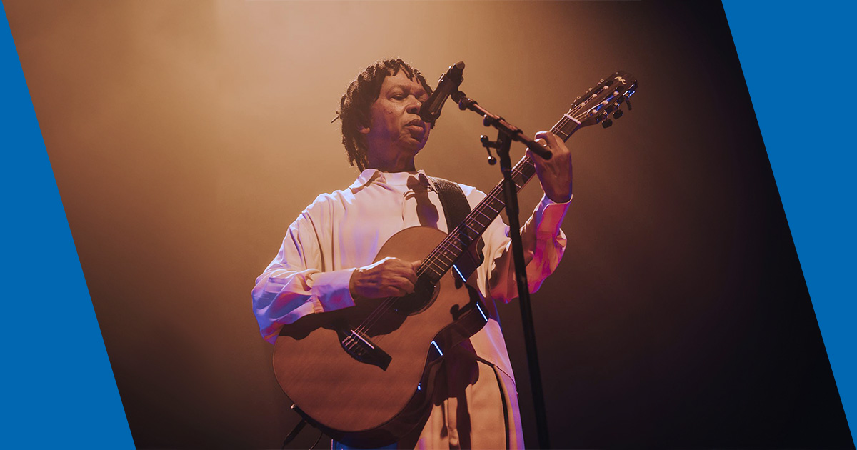 Djavan tocando guitarra en un concierto. 