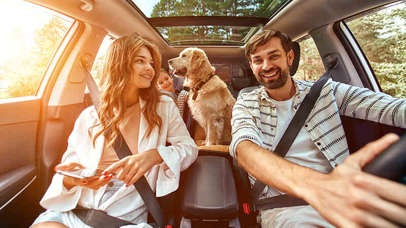 pareja con su perro en el auto